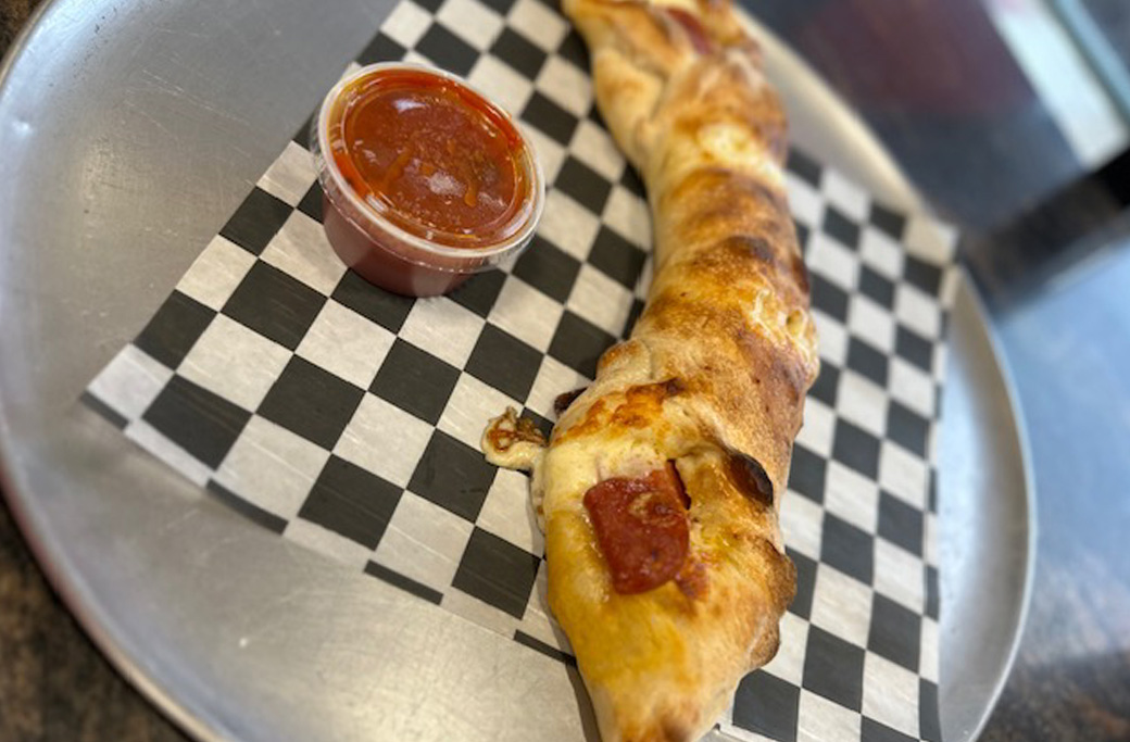 Individual pizza roll filled with melted mozzarella and pepperoni made with pizza dough at Fusaro’s Pizza & Pasta