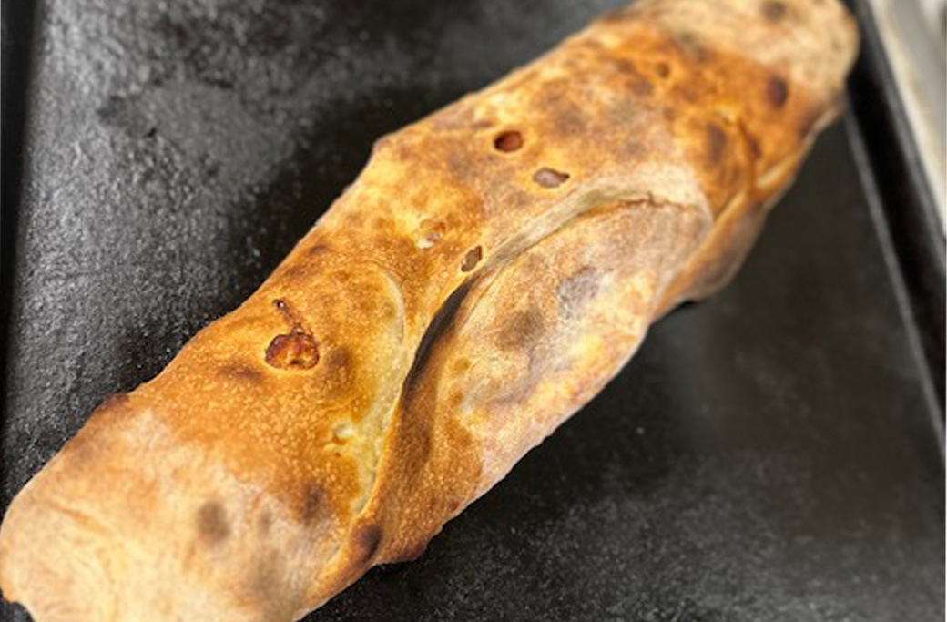Freshly baked stromboli sliced open with mozzarella and savory fillings from Fusaro’s Pizza & Pasta in Manahawkin NJ